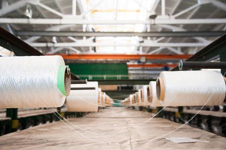 纺织厂纺纱机上的纺织工业纱线线轴照片